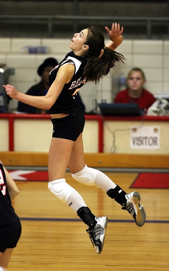 Youth volleyball player jumping to spike